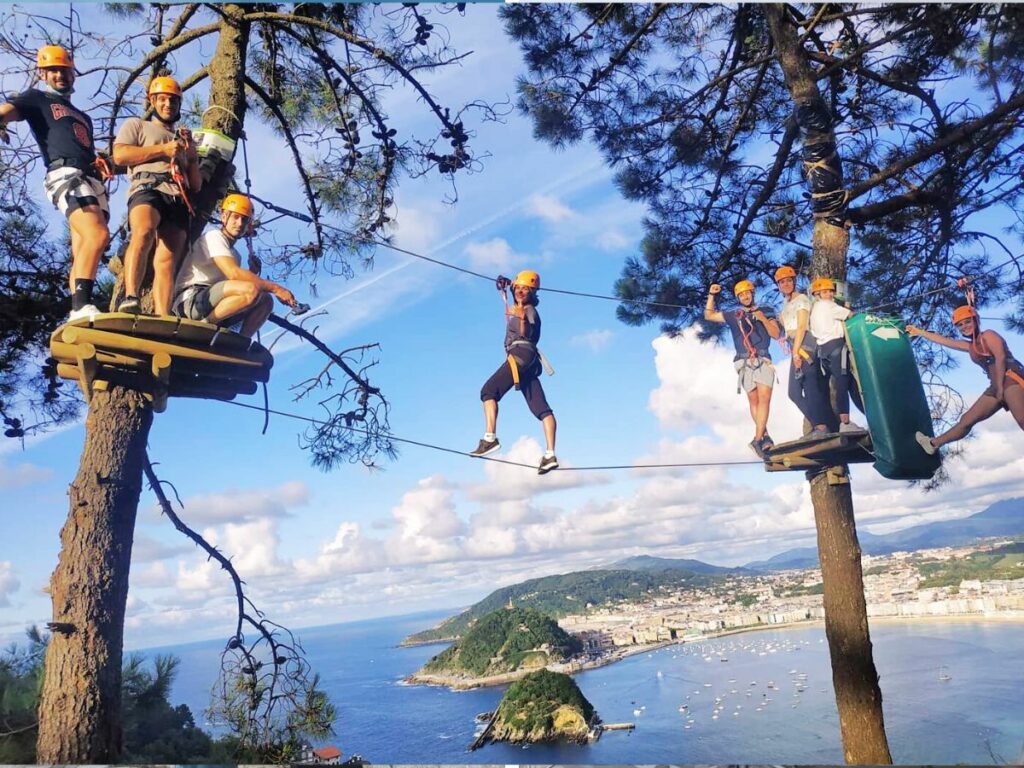 People posing for a photograph at Canopy Zip Wire in Monte Igueldo with San Sebastian views in the background