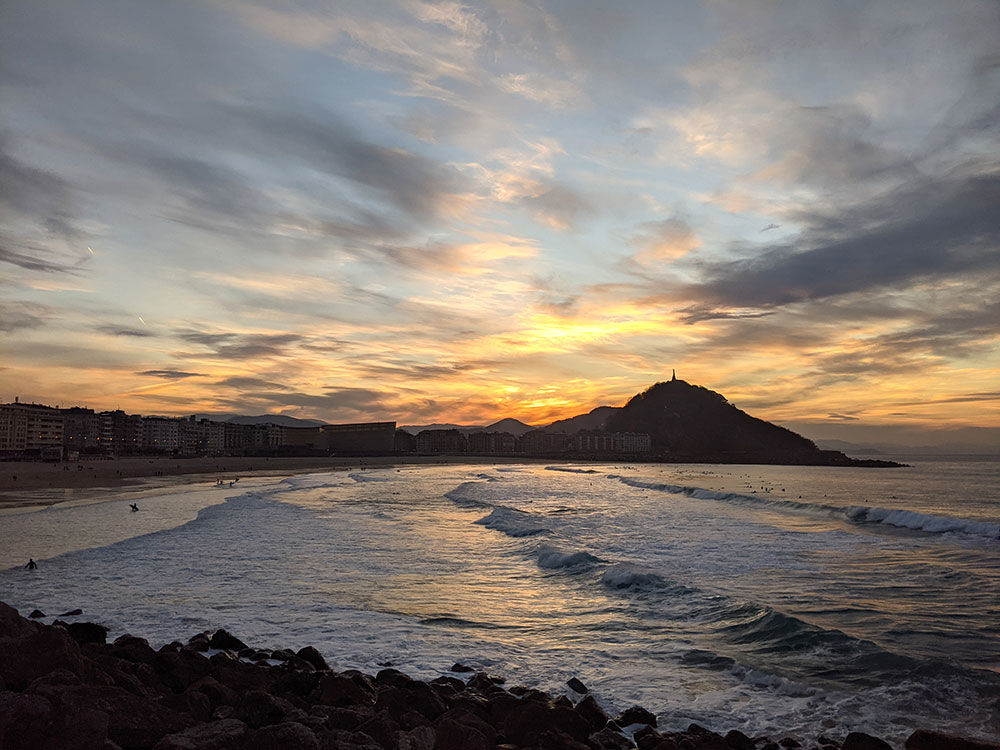 puesta de sol detrás del monte urgull desde la playa de la zurriola